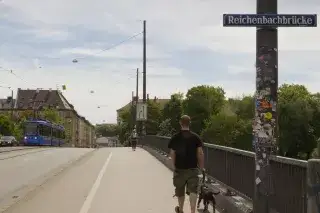 Ein Mann geht mit seinem Hund über die Reichenbachbrücke