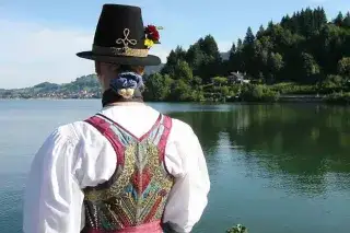 Eine Frau in Tracht am Ufer des Schliersees