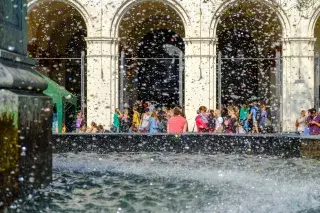 Studenten rund um den Brunnen vor der Ludwig-Maximilians-Universität