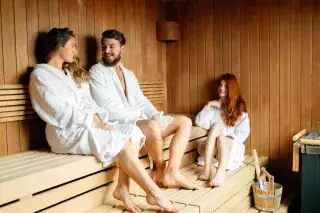 Drei Leute entspannen in der Sauna