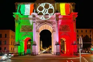 Das Münchner Siegestor bei Nacht bei der UEFA EURO 2020 angeleuchtet in den Landesfarben Italiens und Belgiens