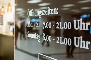 Schild der Öffnungszeiten im Hauptbahnhof Untergeschoss. 