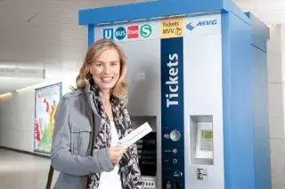 Frau mit Streifenkarte vor Fahrkartenautomat der MVG