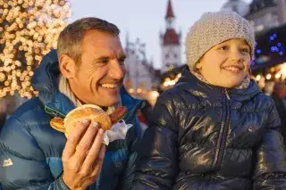 Vater und Kind lassen sich eine Bratwustsemmel schmecken