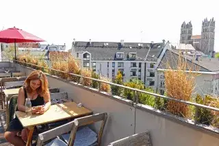 Eine Frau sitzt auf der sonnigen Dachterrasse des Flushing Meadows