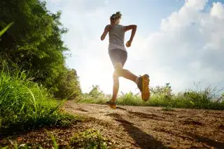 Eine Frau joggt durch den Wald