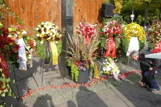 Blumenkränze stehen vor dem Denkmal zum Oktoberfestattentat von 1980.