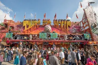 Besucher auf der Wiesn vor der Geisterbahn "Fahrt zur Hölle"