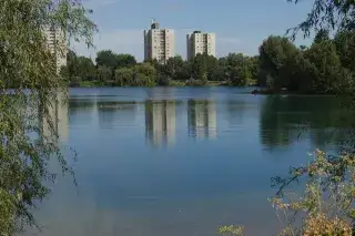 Hochhäuser spiegeln sich im Wasser des Lerchenauer Sees