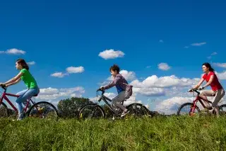 Mutter mit Kindern macht einen Ausflug mit dem Fahrrad