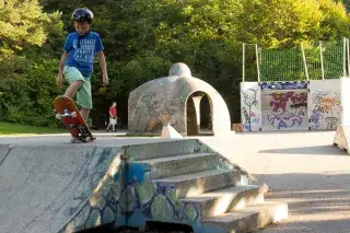 Ein Kind übt mit seinem Skateboard in der Skateanlage im Ostpark