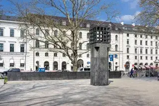 Granitsäule mit brennender Flamme auf dem Platz der Opfer des Nationalsozialismus