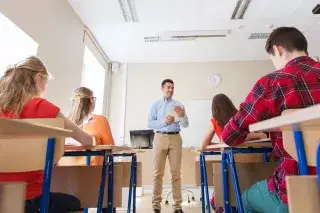 Ein Lehrer unterrichtet vor einer Schulklasse