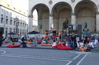 Auf dem Odeonsplatz sitzen Menschen in Sitzsäcken und lesen bei der Aktion StadtLesen.