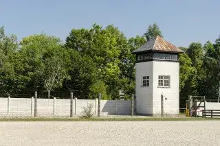 Wachturm, Mauer und Stacheldrahtzaun in der KZ-Gedenkstätte Dachau