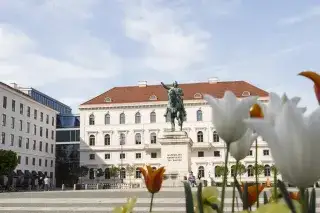 The equestrian monument on Wittelsbacherplatz in summer. Blooming flowers can be seen in the foreground.