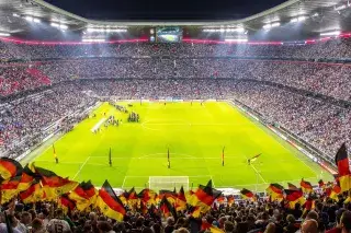 Panorama-Blick auf den Rasen der Allianz Arena, Fans schwenken Deutschland-Fähnchen