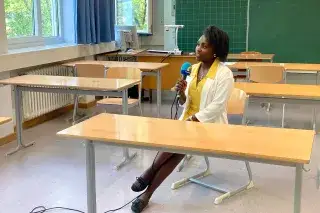 Paschalia Kituto sitz in einem Klassenzimmer auf einem Stuhl