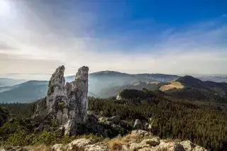 Ausblick auf die Bergformation Pietrele Doamnei in Rumänien mit zwei markanten Bergspitzen umgeben von Wald