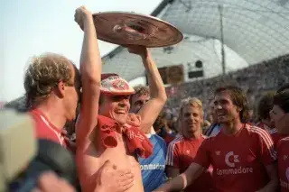 Der dänische Fußballer Sören Lerby reckt im Münchner Olympiastadion die deutsche Meisterschale in die Luft