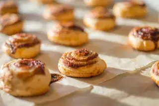 Lots of cinnamon buns on a table