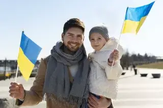 Father and small child with Ukrainian flags