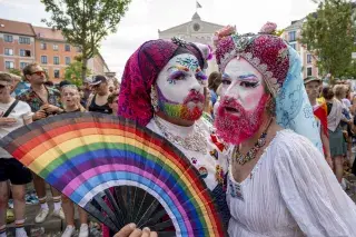 Zwei Drag Kings bei der Politparade mit Regenbogen-Fächer